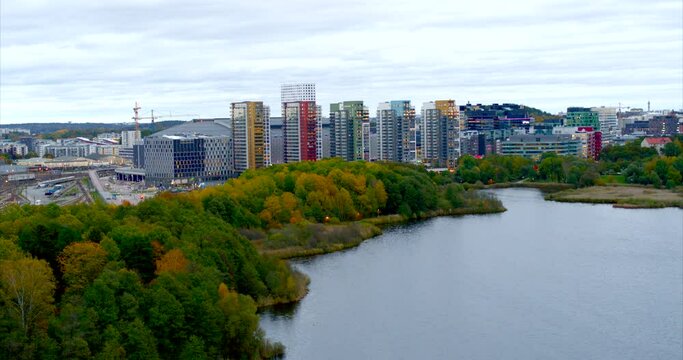 Flying over a lake in central Solna with apartments and sports arena in the background, Sweden