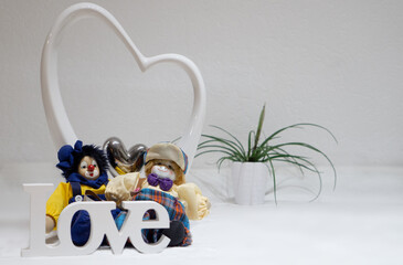 Herz Dekoration mit liebenden Puppen und Love Schriftzug in großem Herz