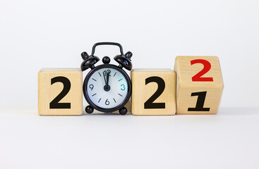 Business concept of 2022 new year. Turned a wooden cube and changed number 2021 to 2022. Black...