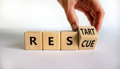 Rescue and restart symbol. Businessman hand turns cubes and changes the word 'rescue' to 'restart'....