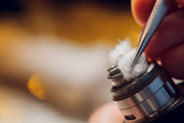 Specialist replaces spring for smoking vape.Professional maintaining electronic cigarette in...
