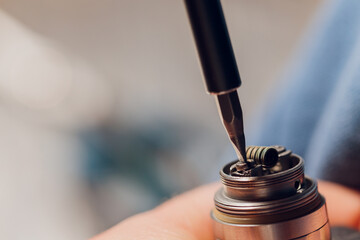 Specialist replaces spring for smoking vape.Professional maintaining electronic cigarette in...