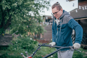 Fototapeta premium A man works in the garden, plows the soil with a cultivator