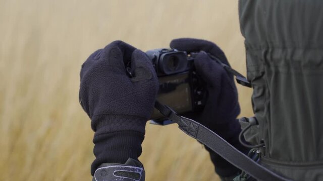 Hooded Person Wearing Gloves Taking Photo On Camera. Slow Motion