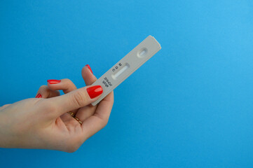 test system for diagnosing coronavirus. a fingerstick test to identify infection. the test is held...