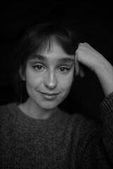 Fototapeta premium black and white portrait of a cute girl close-up on a black background. March 8. Beautiful girl. Day makeup. Thick eyebrows. Trendy eyebrows.