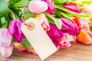 pink and violet tulips with empty tag