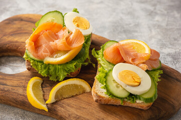 Sandwiches with smoked salmon, salad, cucumbers and eggs.