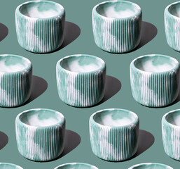 Creative pattern Composition with concrete green and white flower pot. on a green background. Minimalism. Natural material. Eco-friendly.