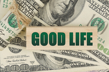 On the dollars is a wooden plate with the inscription - GOOD LIFE