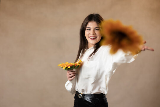 chica joven lanzando flores a la camara