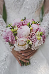 The bride holds a bouquet of roses and peonies in her hands 2651.