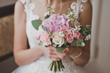 A delicate wedding bouquet in pink tones in the hands of the bride 2657.