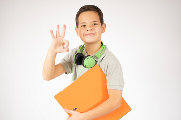 Beautiful young boy with a folder and headphones very surprised