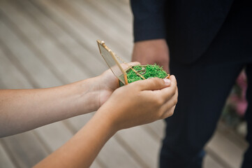 The groom takes a ring from a box with a green bottom 2841.