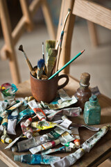 The artists workplace with a bunch of brushes and tubes of paint 2881.