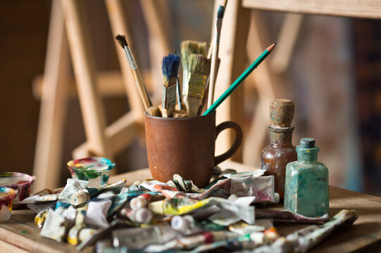 The artists workplace with a bunch of brushes and tubes of paint 2880.