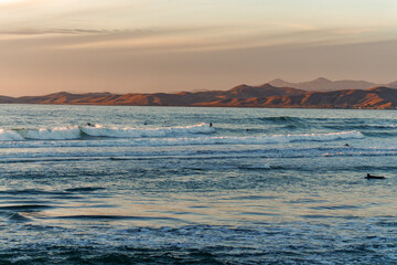 Ocean view at sunset, mountains and cloudy sky on background. Morro Bay, California Central Coast