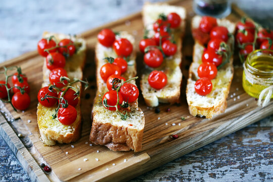 Bruschetta with olive oil and cherry tomatoes. Delicious ciabatta with baked tomatoes.