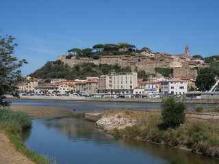 Fototapeta na wymiar Panorama of Castiglione della Pescaia from the mouth of the Bruna river. In the background the upper part of the village with the walls and the castle.