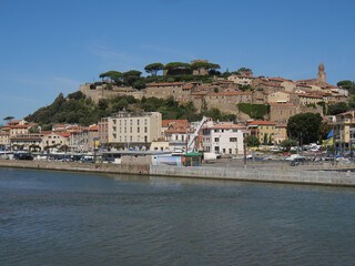 Fototapeta na wymiar Panorama of Castiglione della Pescaia from the mouth of the Bruna river. In the background the upper part of the village with the walls and the castle.
