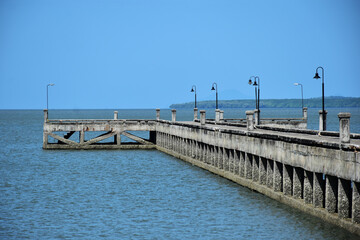 Fototapeta na wymiar concrete jetty into the sea on blue sky background