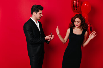 Ginger girl rejects proposal. Studio photo of upset couple posing in valentine's day.