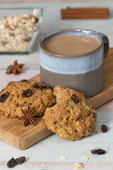 Chocolate Chip and Oatmeal Cookies in white plate on wooden background and decorated with pink flower- cookies for mom on mothers day top side view