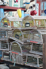 stacks of wooden lobster traps and buoys in nautical setting