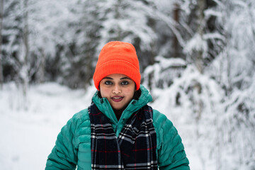 Fototapeta na wymiar An asian model woman in a winter wonderland enjoying the snow wearing colourful cloths