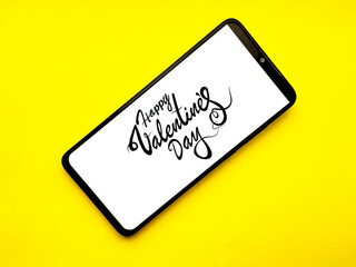 Phone with Valentine's happy day inscription on a yellow background