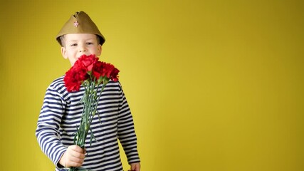 The boy in green military cap gives red flowers carnation May 9, 23 February, gratitude and remembrance of war and victory day concept
