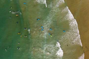Fototapeta na wymiar Aerial images of learner surfers in a group at Fistral beach, Newquay, Cornwall