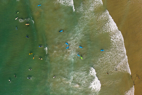 Aerial images of learner surfers in a group at Fistral beach, Newquay, Cornwall