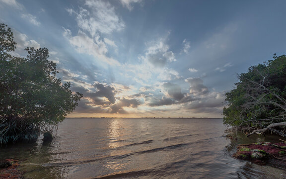 Dramatic view of sunbeams bursting from behind clouds at sunset