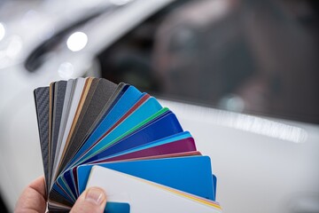 Man choosing color of his car with color sampler. Car foil wrapping colors picker