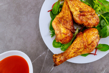 Grilled chicken drumsticks marinated with buffalo sauce.
