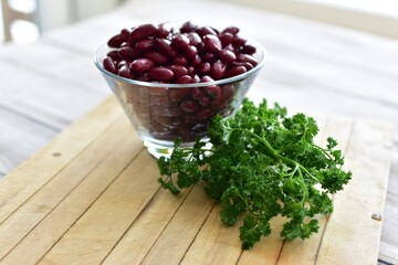 Red Kidney beans in glass bowl with fresh herbs ready for preparing healthy vegan or vegetarian meals. Simple bowl of beans photo concept with copy space