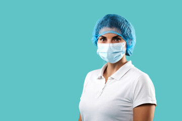 Portrait of a woman doctor wearing medical uniform and protective mask and gloves standing against blue background