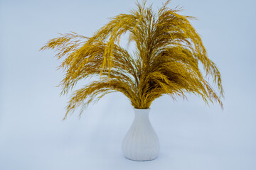 orange color flower in white stone vase.
