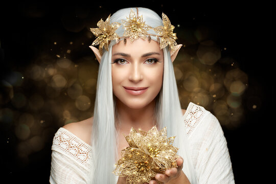 Attractive Friendly female elf with golden flowers. Young woman in elf costume
