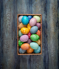 Easter eggs in a box on wooden background