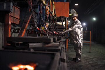 Foundry worker preparing molds for hot molten steel.