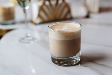 A glass of cappuccino on the table in a cafe