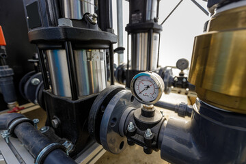 Close up of water pressure sensor or manometer with pipes and valves. Industrial concept