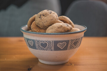 Cookies with chocolate in a white cute cup standing on a table.