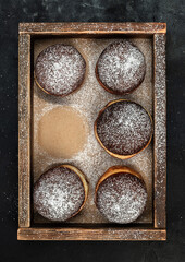 Jelly filled doughnuts with powdered sugar in a box