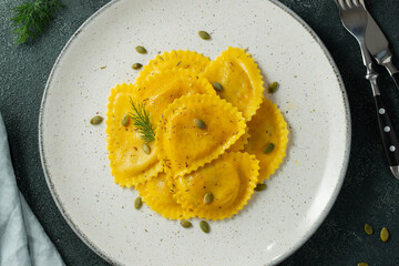Homemade Pumpkin Ravioli with butter on a dark concrete background. Top view
