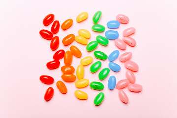 Sweet rainbow jelly beans on pink background. Top view