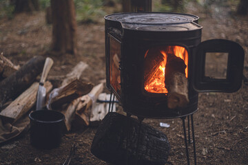 冬のキャンプ。薪ストーブに木をくべる。